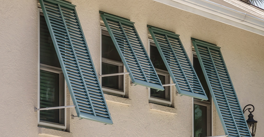 A structure with green shutters and a clock, representing advice on preparing your home for storms.