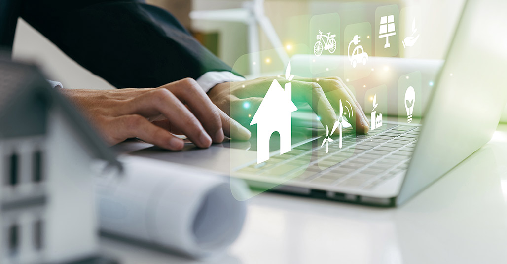 A man in a suit types on a laptop with icons, researching custom home builders in McAllen.