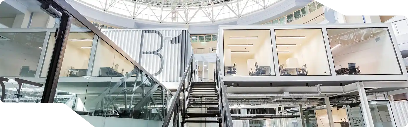 A modern glass atrium featuring stairs and a glass wall, part of a custom commercial building in McAllen.