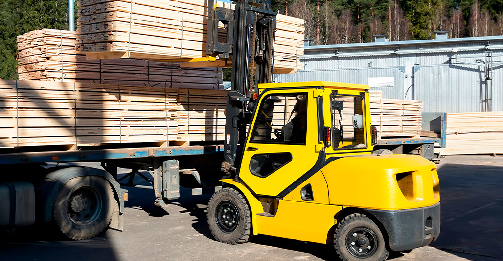 A forklift truck stands idle outside a building, representing commercial construction in South Texas.
